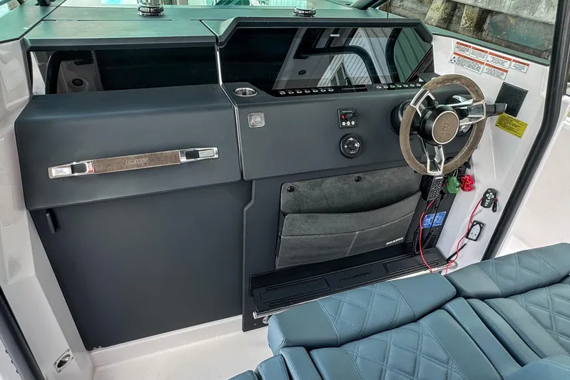  Yacht Photos Pics 2022 Axopar 37 Sun-Top helm with modern steering wheel and dashboard controls.