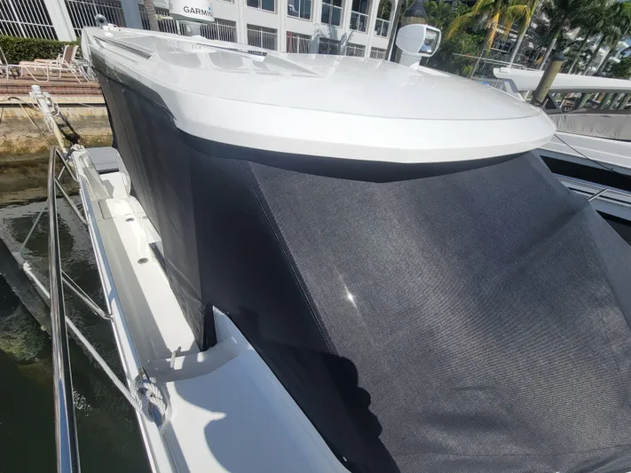  Yacht Photos Pics 2020 Jeanneau NC1095 boat with sunshade, docked near waterfront buildings.