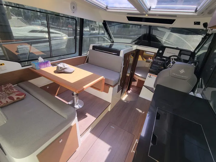  Yacht Photos Pics Interior of 2020 Jeanneau NC1095 boat with seating, table, and helm station.