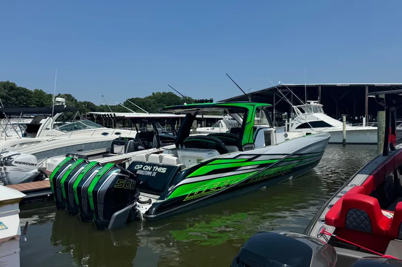  Yacht Photos Pics 2024 Deep Impact 399 Sport boat with vibrant green accents docked at a marina.