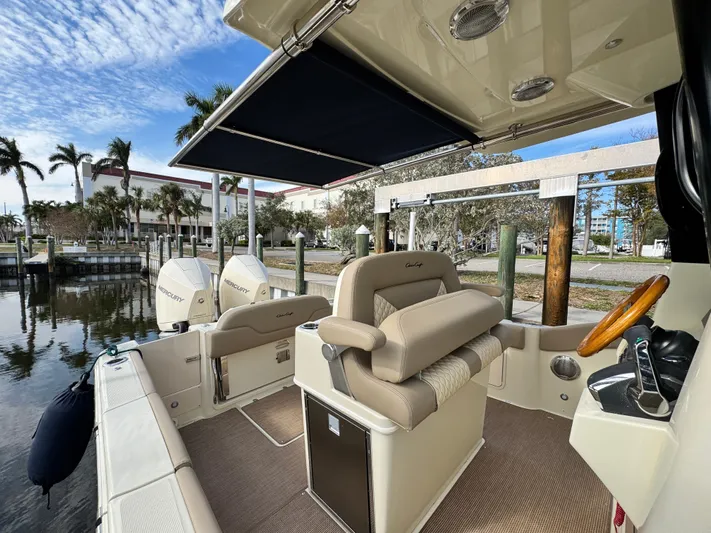  Yacht Photos Pics 2025 Chris-Craft Catalina 28 boat interior with helm, seating, and dual engines at dock.