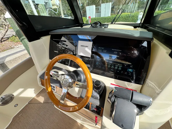  Yacht Photos Pics 2025 Chris-Craft Catalina 28 helm with wooden steering wheel and modern dashboard.
