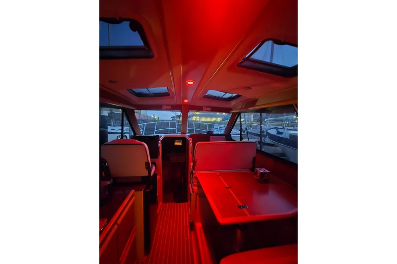  Yacht Photos Pics Interior of 2015 Cutwater C28 boat with red lighting and seating area.