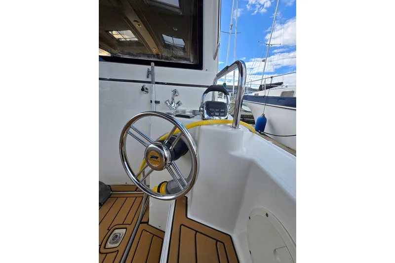  Yacht Photos Pics 2015 Cutwater C28 boat helm with steering wheel and control panel, docked under blue sky.