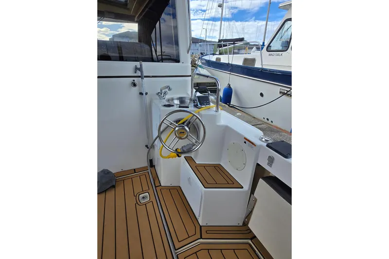  Yacht Photos Pics 2015 Cutwater C28 boat cockpit with wooden flooring and steering wheel.