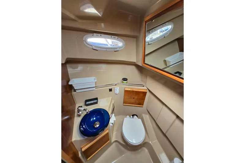  Yacht Photos Pics 2015 Cutwater C28 boat bathroom with blue sink, toilet, and mirror.