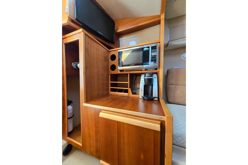  Yacht Photos Pics 2015 Cutwater C28 interior with microwave, coffee maker, and wooden cabinetry.