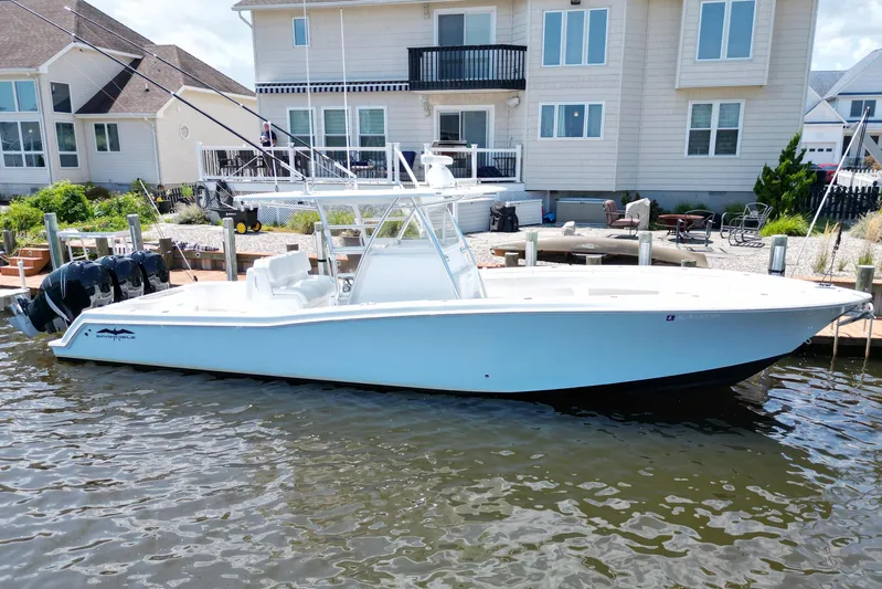  Yacht Photos Pics 2018 Invincible 36 Open Fisherman boat docked by waterfront homes.