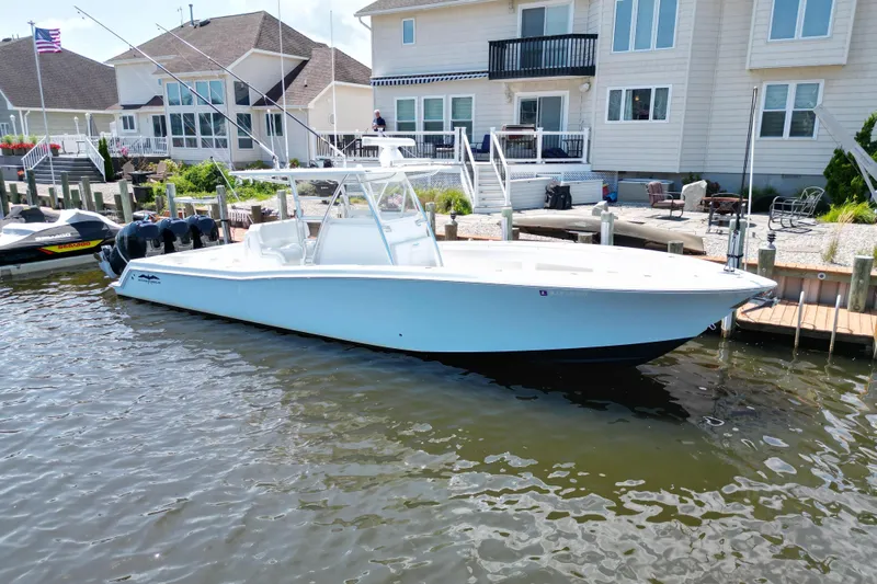  Yacht Photos Pics 2018 Invincible 36 Open Fisherman boat docked near waterfront homes.