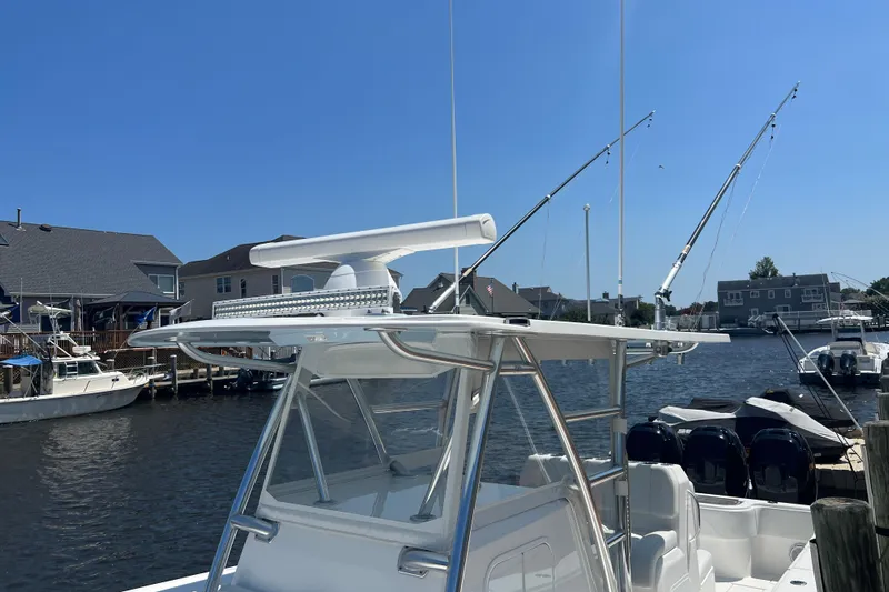  Yacht Photos Pics 2018 Invincible 36 Open Fisherman boat docked with fishing rods and clear blue sky.