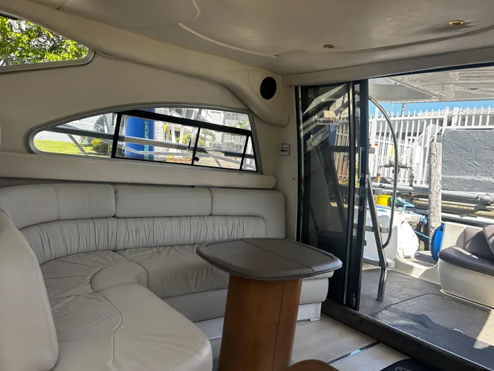  Yacht Photos Pics Interior of 2003 Cranchi Atlantique 40 yacht with white leather seating and wooden table.