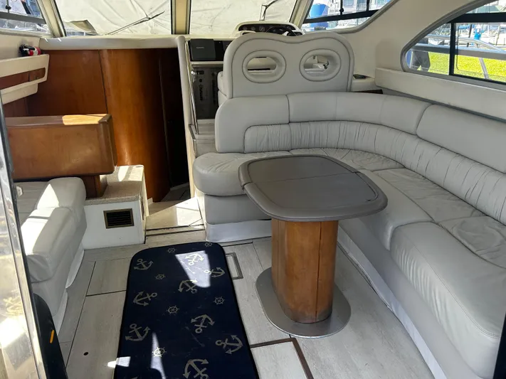  Yacht Photos Pics Interior of 2003 Cranchi Atlantique 40 yacht with white leather seating and wooden table.