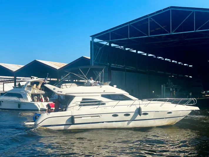  Yacht Photos Pics 2003 Cranchi Atlantique 40 yacht docked near a marina under a clear blue sky.