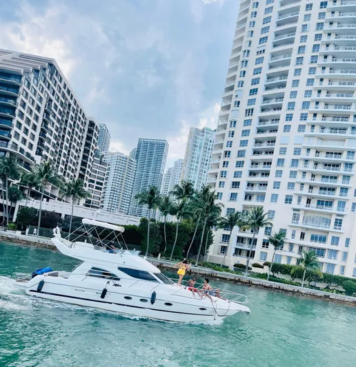  Yacht Photos Pics 2003 Cranchi Atlantique 40 yacht cruising near waterfront skyscrapers and palm trees.
