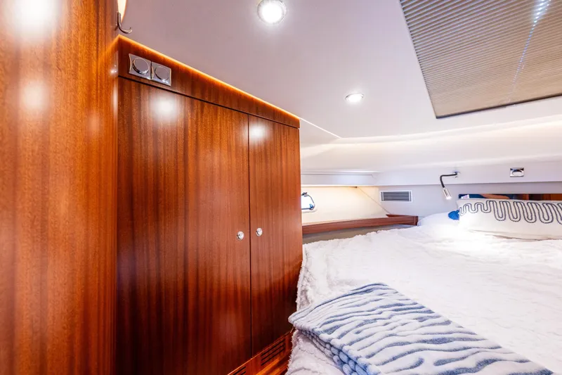Endeavour Yacht Photos Pics Luxurious cabin interior of 2023 Nimbus 405 Flybridge yacht with wood paneling and cozy bedding.
