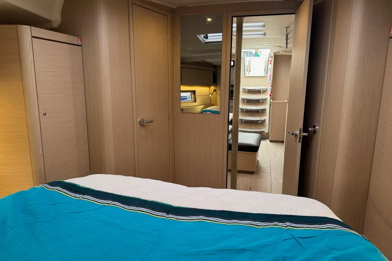  Yacht Photos Pics 2024 Beneteau Oceanis 46.1 interior cabin with modern wood finish and cozy bedding.