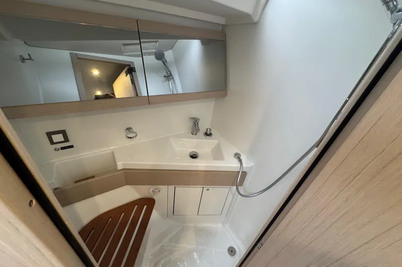  Yacht Photos Pics Modern bathroom in 2024 Beneteau Oceanis 46.1 yacht with sleek fixtures and wooden accents.