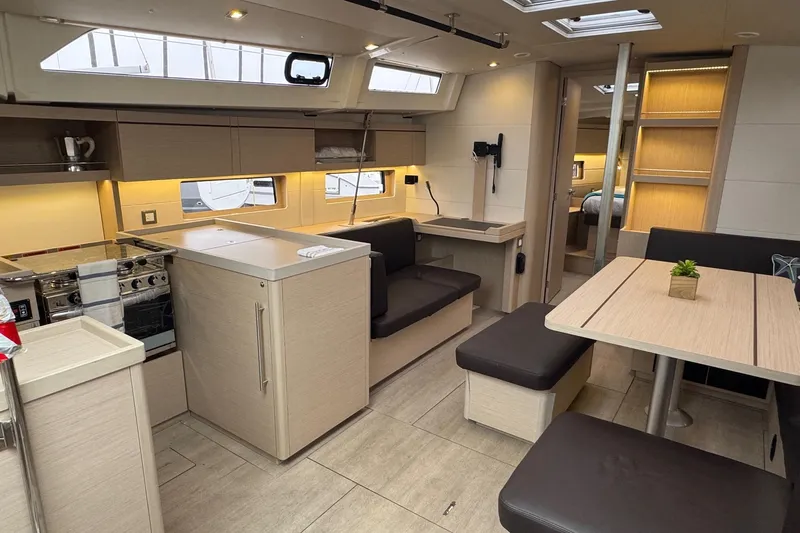  Yacht Photos Pics Modern interior of 2024 Beneteau Oceanis 46.1 yacht with sleek kitchen and dining area.