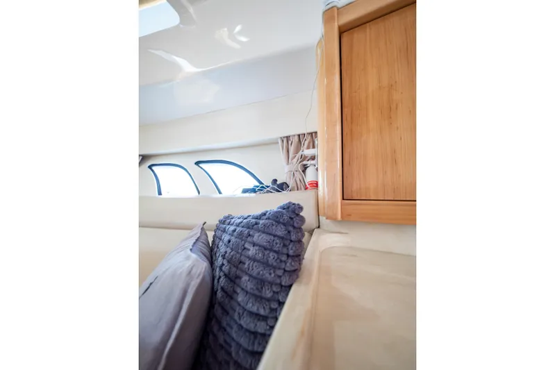  Yacht Photos Pics Interior of 2018 Intrepid 475 Sport Yacht with plush pillows and wooden cabinetry.