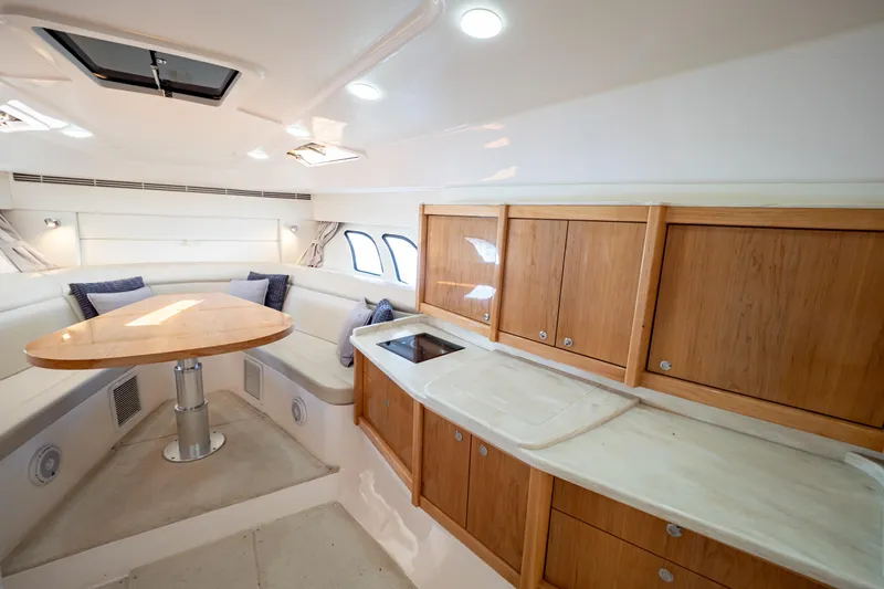  Yacht Photos Pics Luxurious interior of 2018 Intrepid 475 Sport Yacht with wooden cabinetry and seating area.