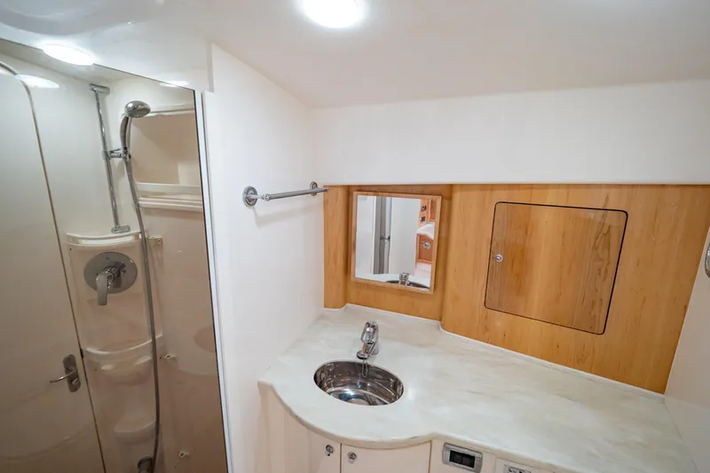  Yacht Photos Pics Luxurious bathroom in 2018 Intrepid 475 Sport Yacht with modern fixtures and wood accents.