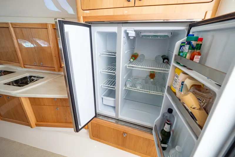  Yacht Photos Pics Open fridge in 2018 Intrepid 475 Sport Yacht kitchen, stocked with beverages and condiments.