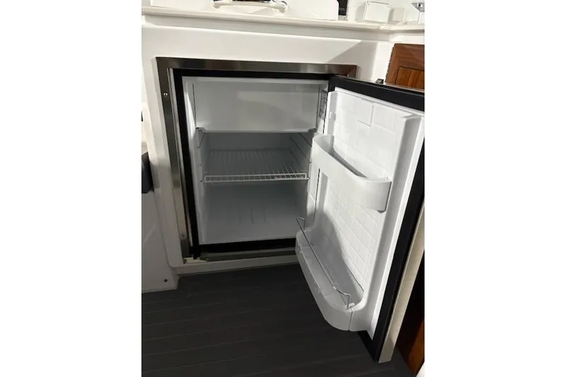  Yacht Photos Pics Open refrigerator inside 2023 Cruisers Yachts 38 GLS OB boat, showcasing interior storage space.