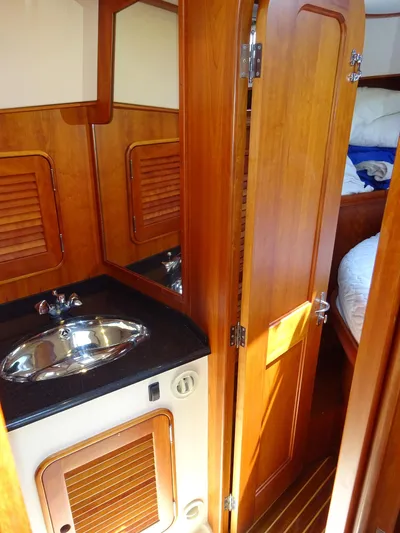 Fine Time Yacht Photos Pics 2002 Hinckley Talaria 44 FB yacht interior with wooden cabinetry and compact sink area.
