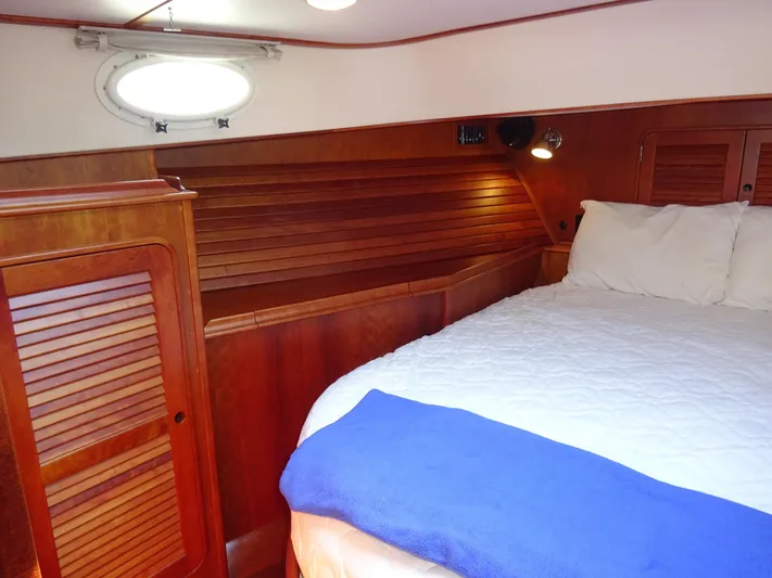 Fine Time Yacht Photos Pics Cabin interior of 2002 Hinckley Talaria 44 FB with wooden paneling and cozy bedding.