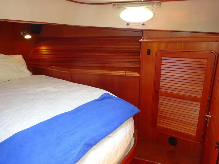 Fine Time Yacht Photos Pics Cabin interior of 2002 Hinckley Talaria 44 FB with wooden paneling and cozy bedding.