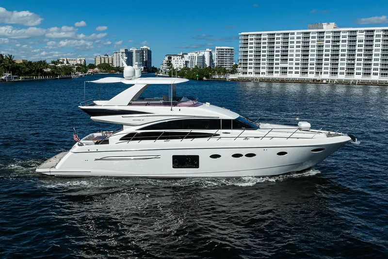 Tight Squeeze Yacht Photos Pics Luxury 2016 Princess F64 yacht cruising near waterfront buildings under blue sky.