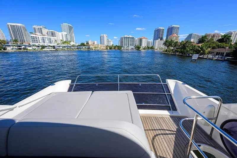 Tight Squeeze Yacht Photos Pics Luxury yacht Princess F64, 2016 model, cruising near city skyline and waterfront homes.