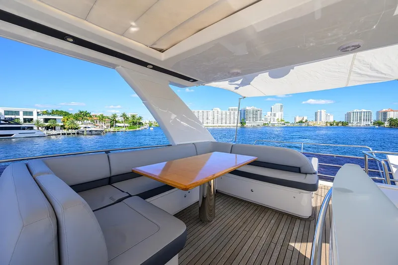 Tight Squeeze Yacht Photos Pics Luxurious 2016 Princess F64 yacht with elegant seating, overlooking waterfront cityscape.
