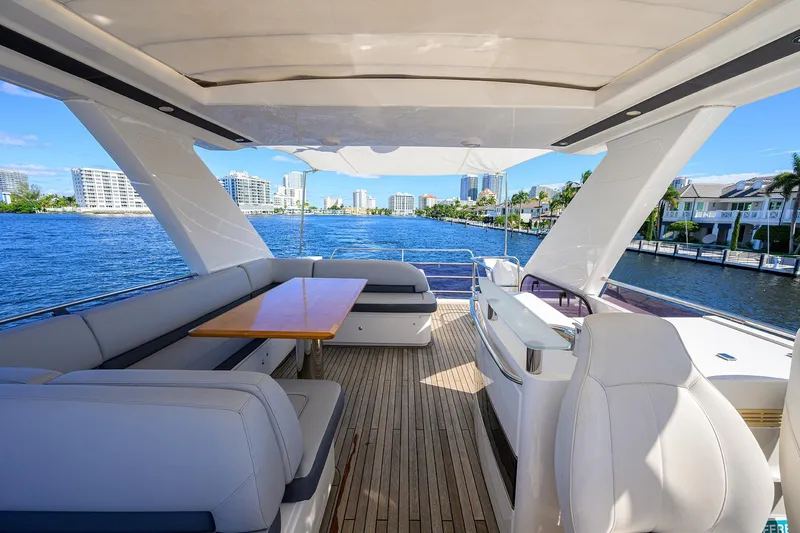 Tight Squeeze Yacht Photos Pics Luxurious 2016 Princess F64 yacht deck with seating, table, and waterfront view.