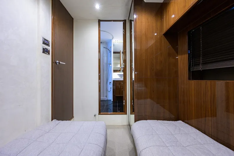 Tight Squeeze Yacht Photos Pics Luxurious interior of 2016 Princess F64 yacht with twin beds and wooden paneling.