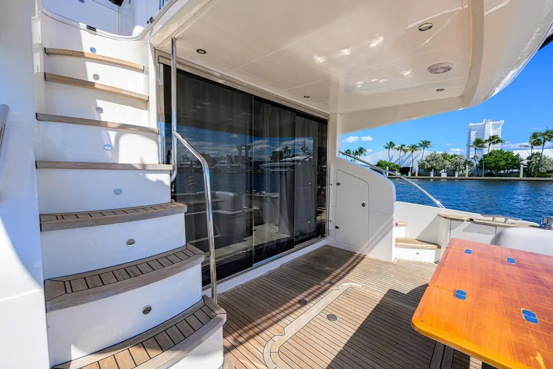 Tight Squeeze Yacht Photos Pics Luxurious 2016 Princess F64 yacht deck with wooden stairs and waterfront view.