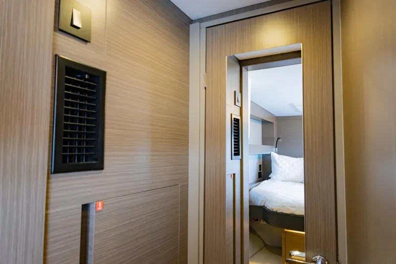 Mabinti Yacht Photos Pics Interior cabin view of 2024 Leopard 40 Powercat, featuring modern wood paneling and cozy bedding.