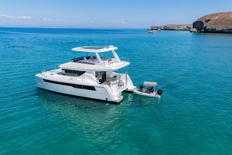 Mabinti Yacht Photos Pics 2024 Leopard 40 Powercat yacht on clear blue water near rocky coastline.