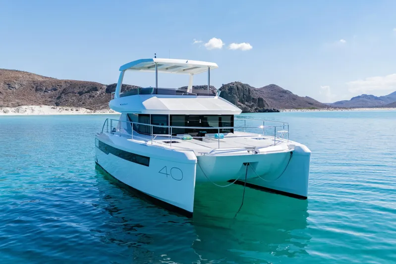 Mabinti Yacht Photos Pics 2024 Leopard 40 Powercat yacht on clear turquoise water, scenic coastal backdrop.