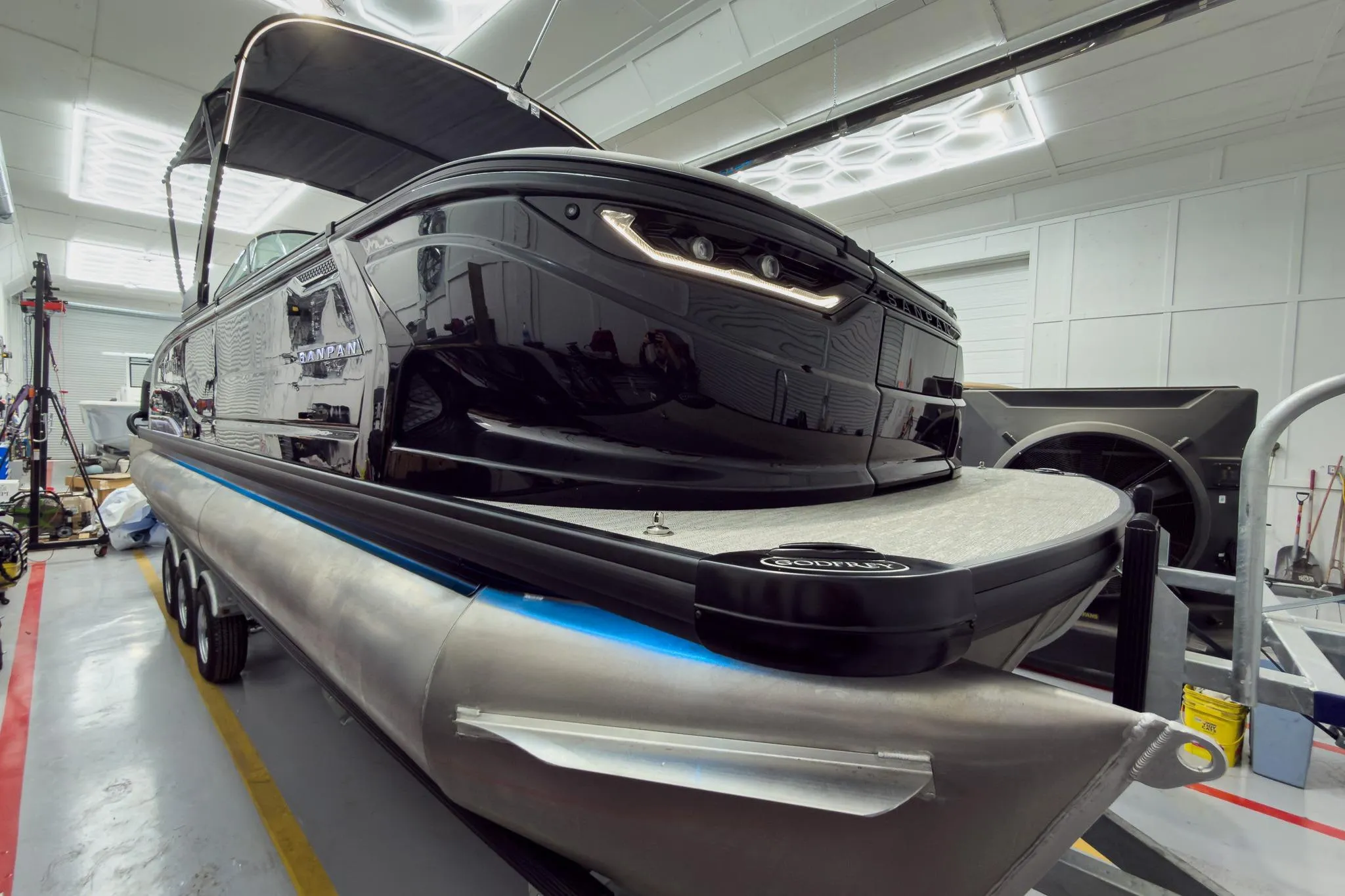 2026 Godfrey Sanpan 27' Tritoon boat in a workshop, showcasing sleek design and modern features.