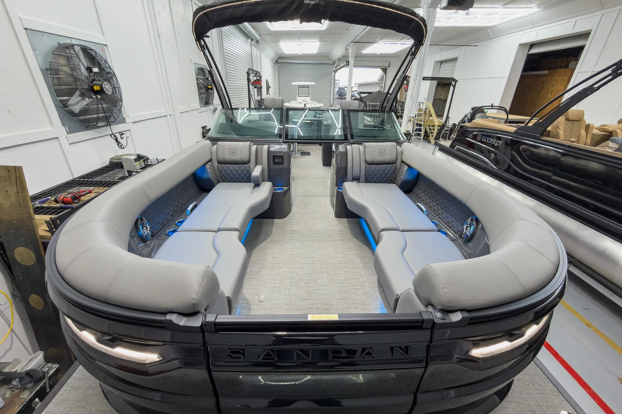 2026 Godfrey Sanpan 27' Tritoon with luxurious seating and modern design in a showroom.