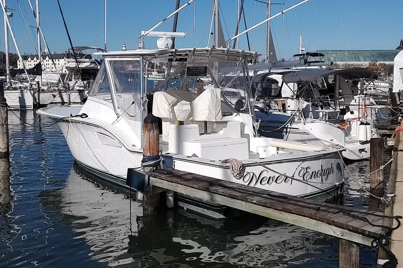Never Enough Yacht Photos Pics 2017 Out Island SeaTek 36 Express docked at marina, surrounded by sailboats.