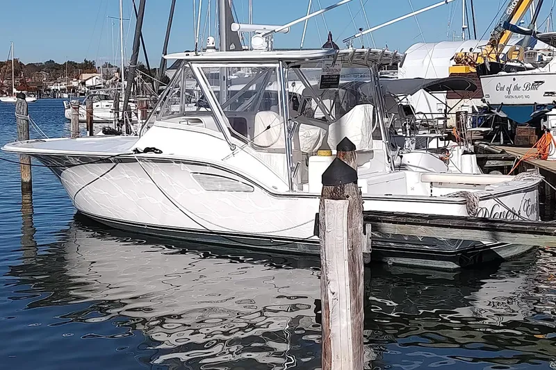 Never Enough Yacht Photos Pics 2017 Out Island SeaTek 36 Express boat docked in a marina, reflecting on calm water.