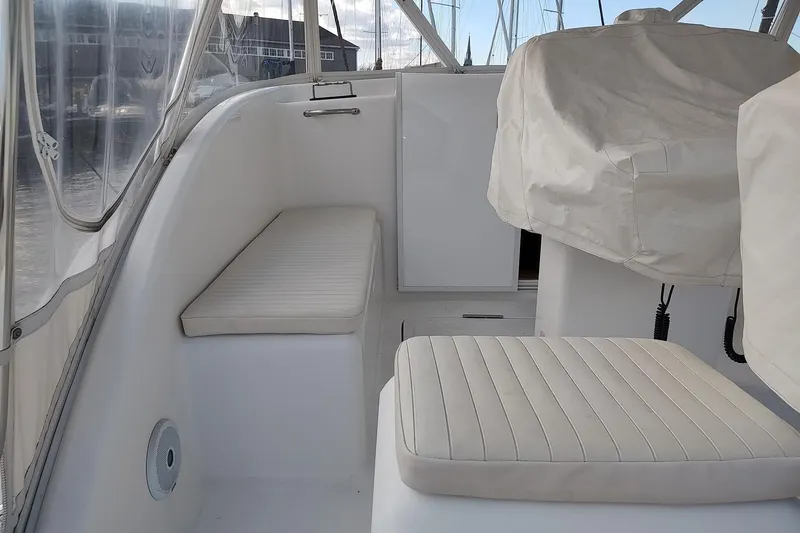 Never Enough Yacht Photos Pics 2017 Out Island SeaTek 36 Express boat interior with white seating and covered controls.
