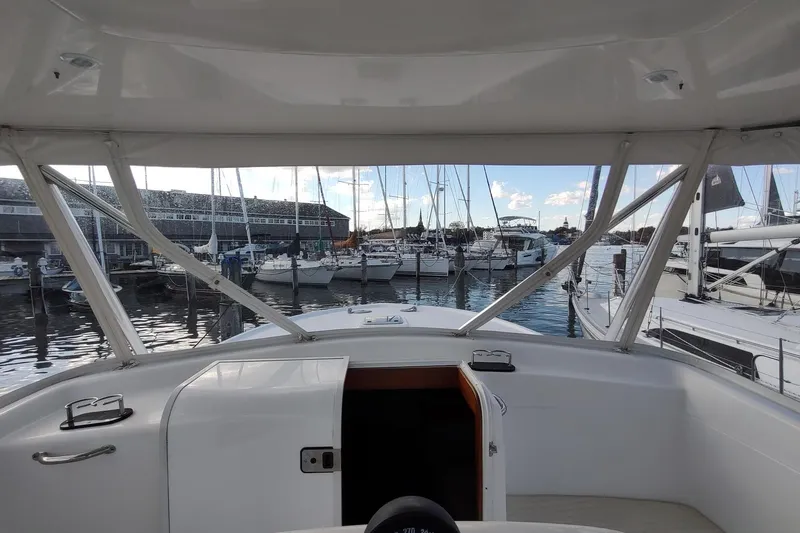 Never Enough Yacht Photos Pics 2017 Out Island SeaTek 36 Express yacht docked at marina, surrounded by sailboats.