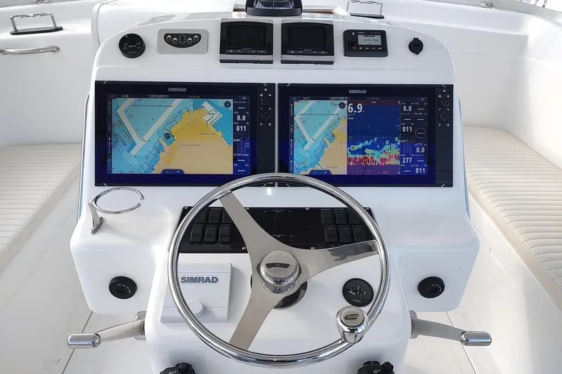 Never Enough Yacht Photos Pics 2017 Out Island SeaTek 36 Express helm with dual Simrad displays and steering wheel.