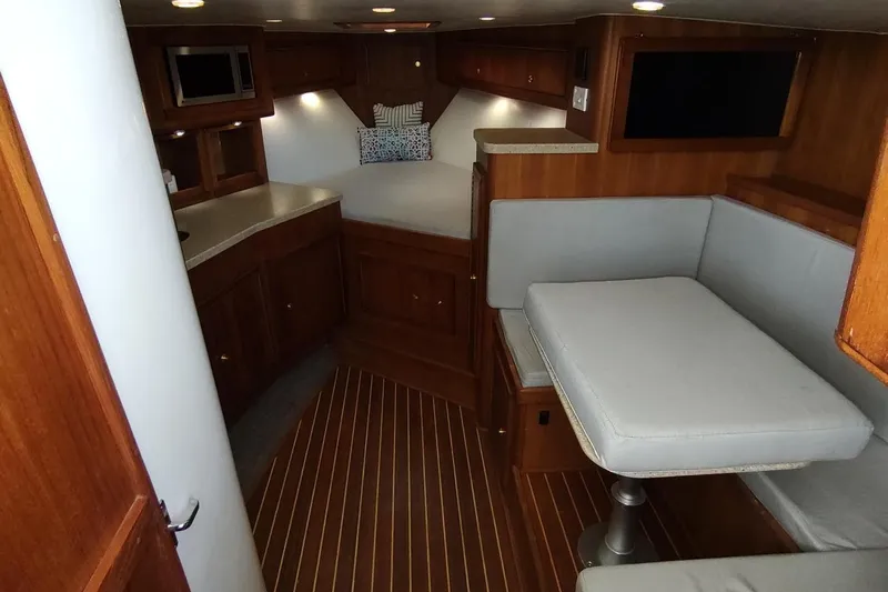 Never Enough Yacht Photos Pics 2017 Out Island SeaTek 36 Express cabin interior with wood finish and seating area.
