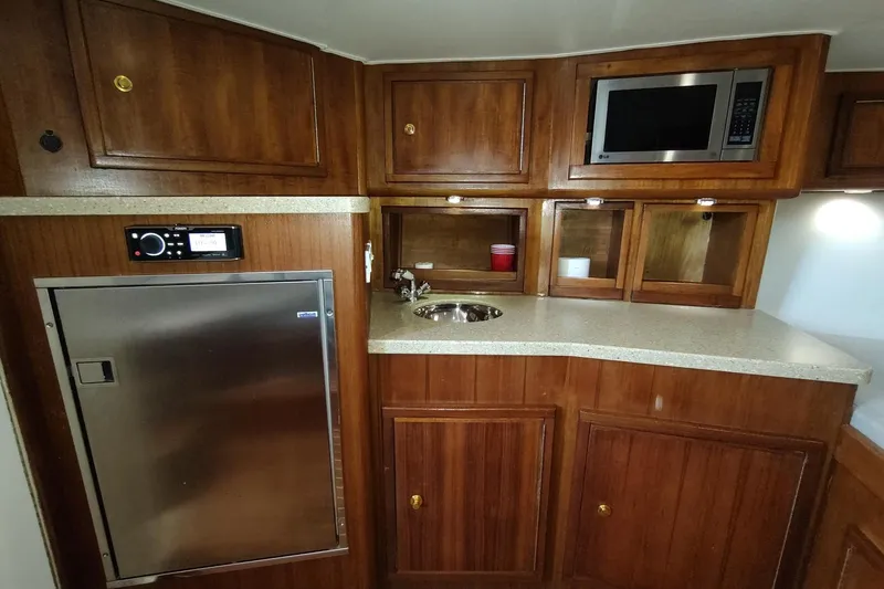 Never Enough Yacht Photos Pics 2017 Out Island SeaTek 36 Express yacht kitchen with wood cabinets and modern appliances.