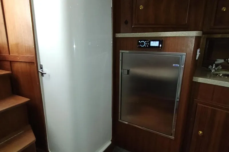 Never Enough Yacht Photos Pics 2017 Out Island SeaTek 36 Express interior with wooden cabinetry and stainless steel appliances.