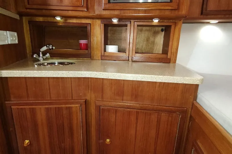 Never Enough Yacht Photos Pics 2017 Out Island SeaTek 36 Express interior with wooden cabinetry and countertop sink.
